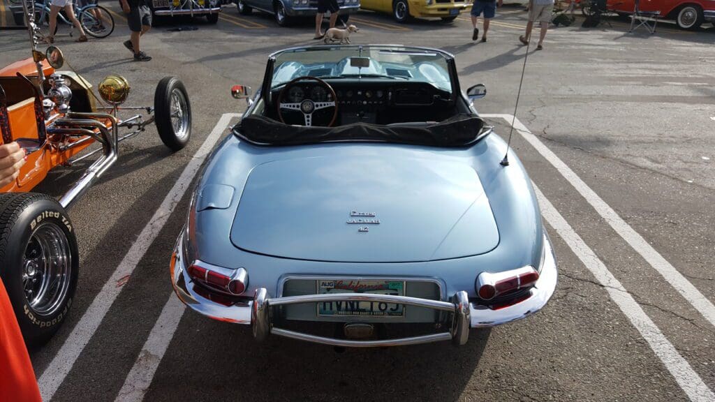 Classic blue Jaguar E-Type sports car displayed at a car show.