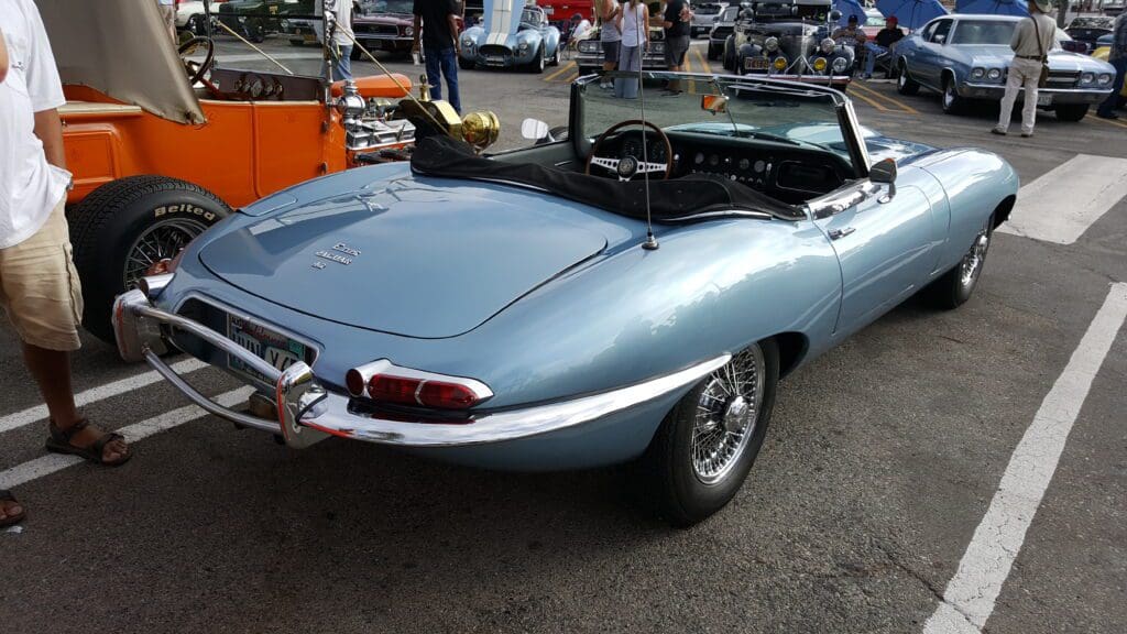 Classic silver Jaguar E-Type convertible parked outdoors.