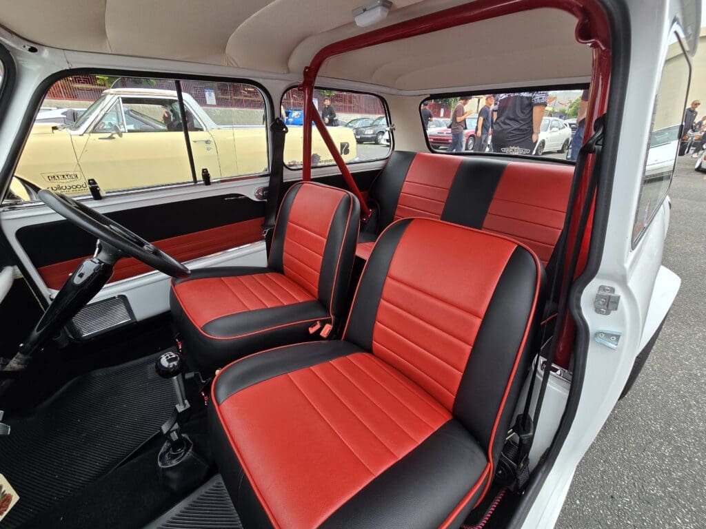 Interior of a classic car with red and black seats.
