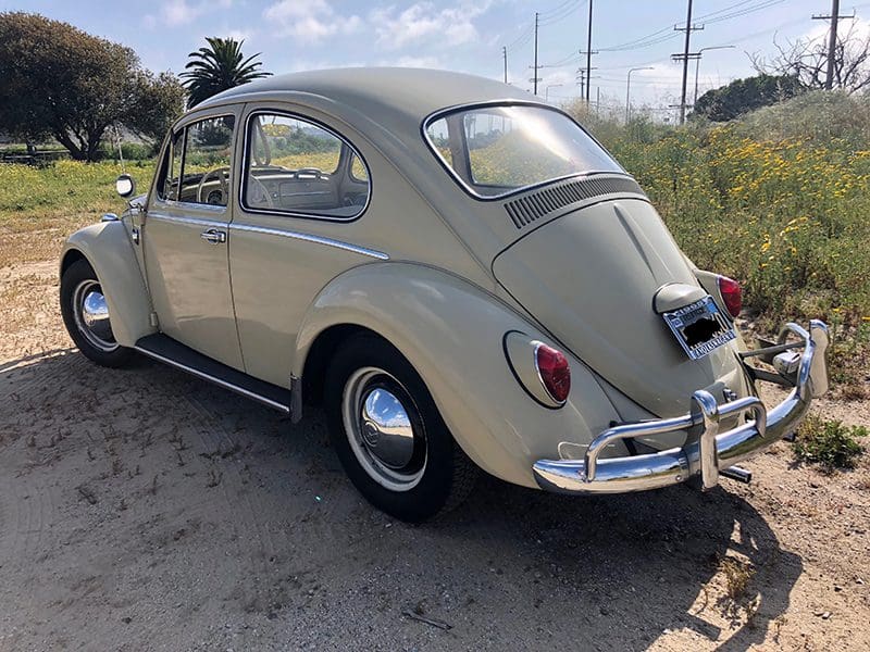 Classic beige Volkswagen Beetle parked outdoors on a sunny day.