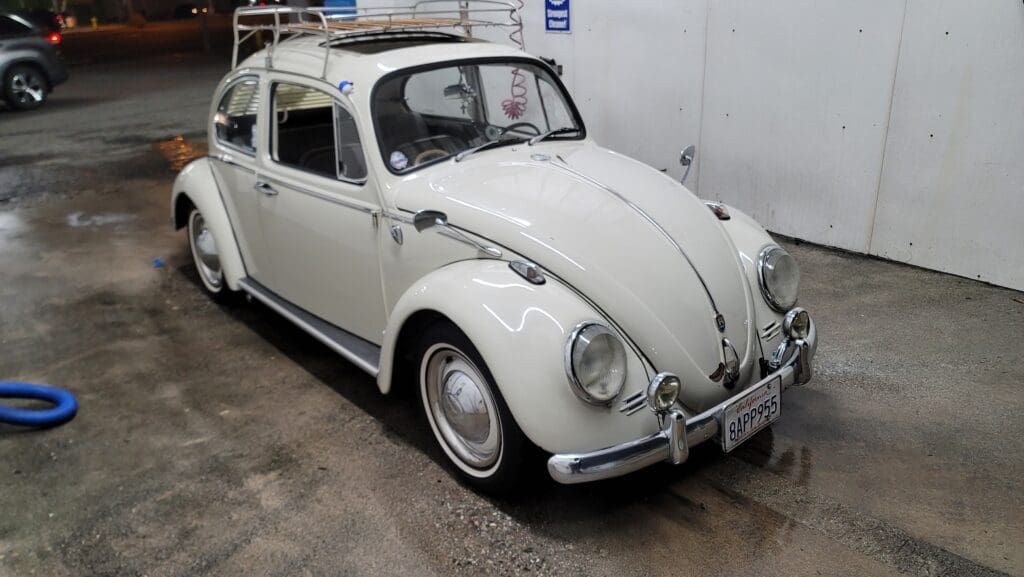 Classic white Volkswagen Beetle parked indoors.