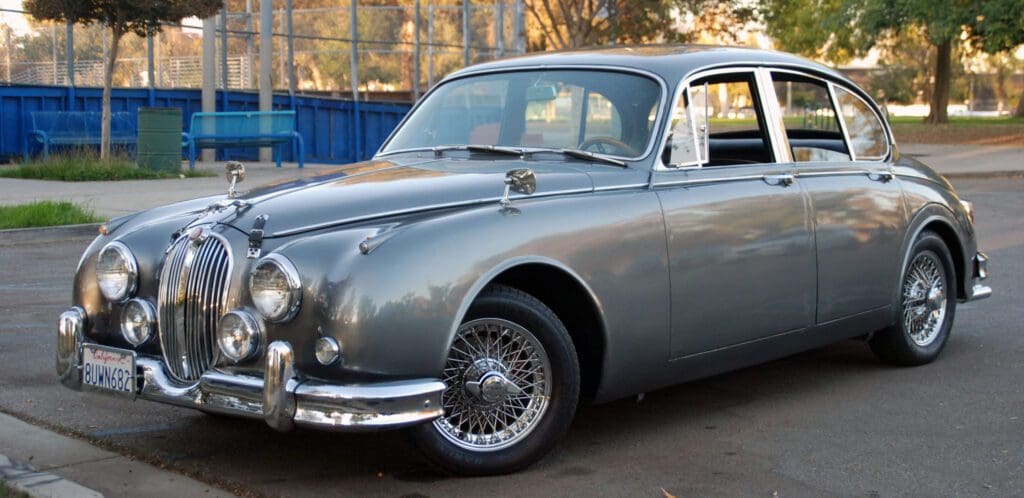 Classic silver vintage car parked outdoors.