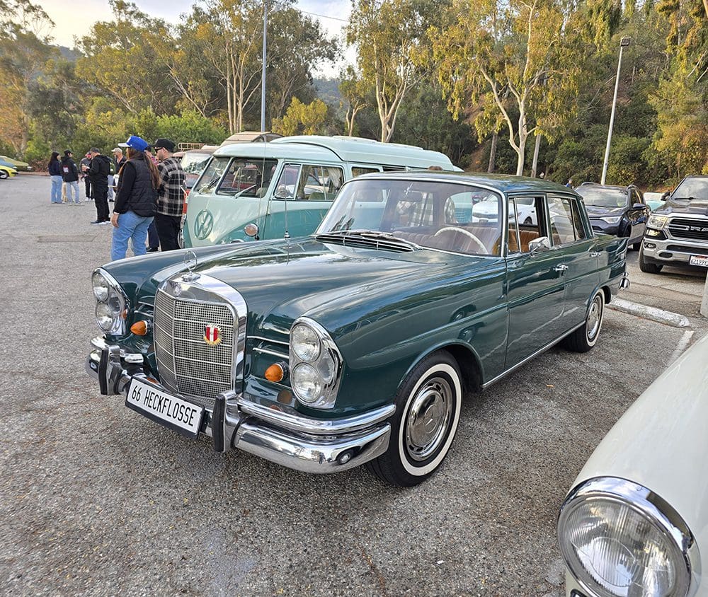 Classic green Mercedes-Benz car parked at a vintage car show.