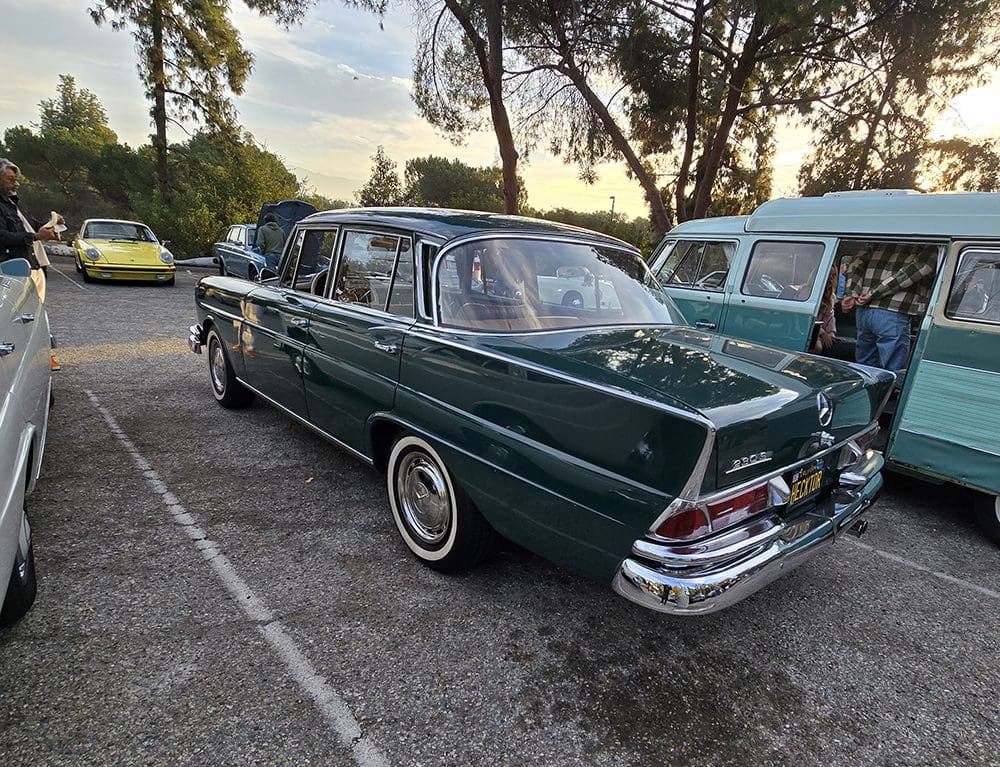 Classic green vintage car parked outdoors during the day.