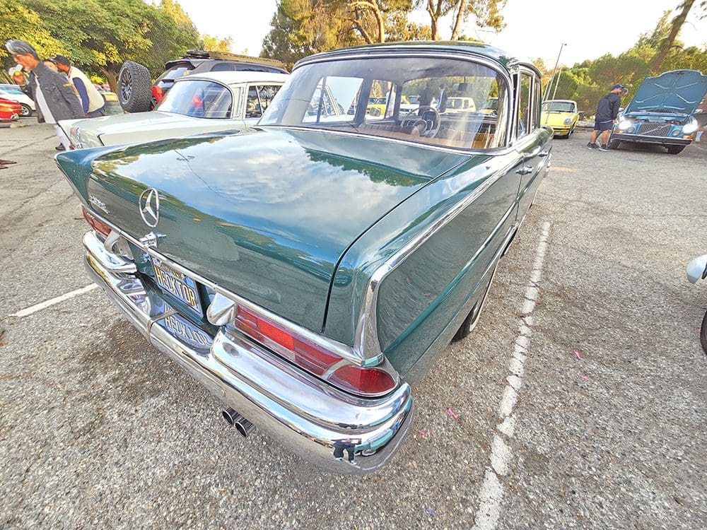 Classic green vintage car parked in a lot.