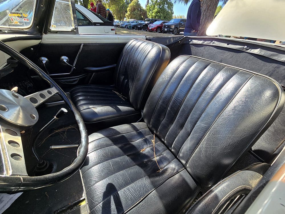 Classic car with well-maintained black leather interior seats.