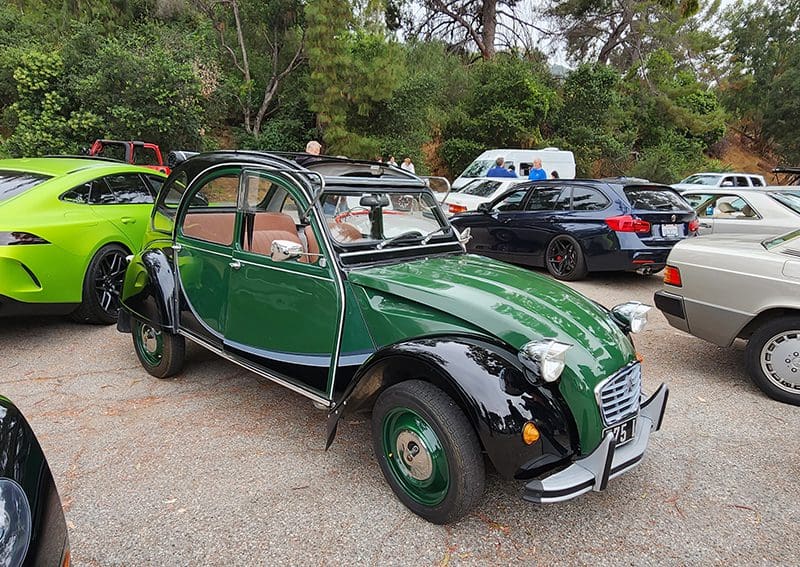 Classic green and black vintage car parked outdoors.