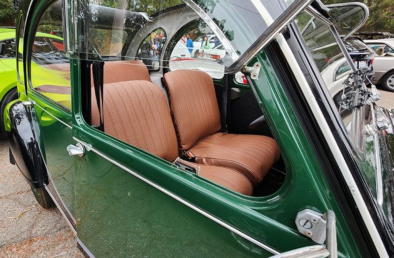 Interior of a vintage green car with brown seats.