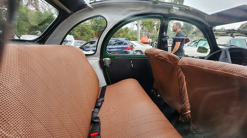 Interior view of a car showing front and back seats from the rear window.