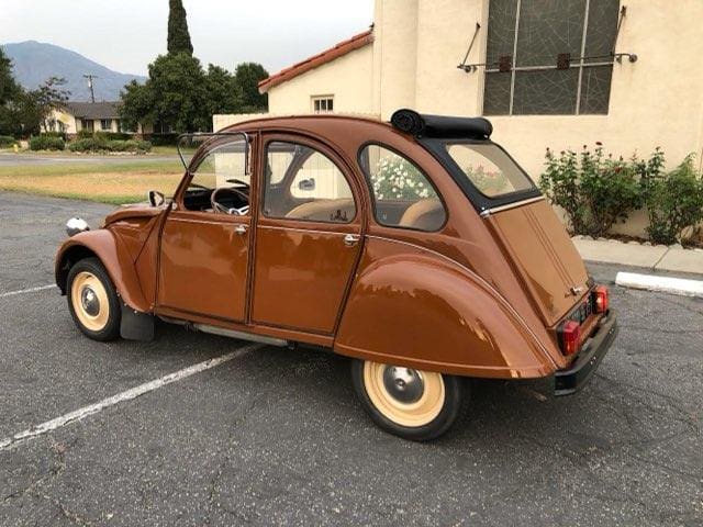 Classic vintage brown Citro&euml;n 2CV parked outdoors with a sunroof.