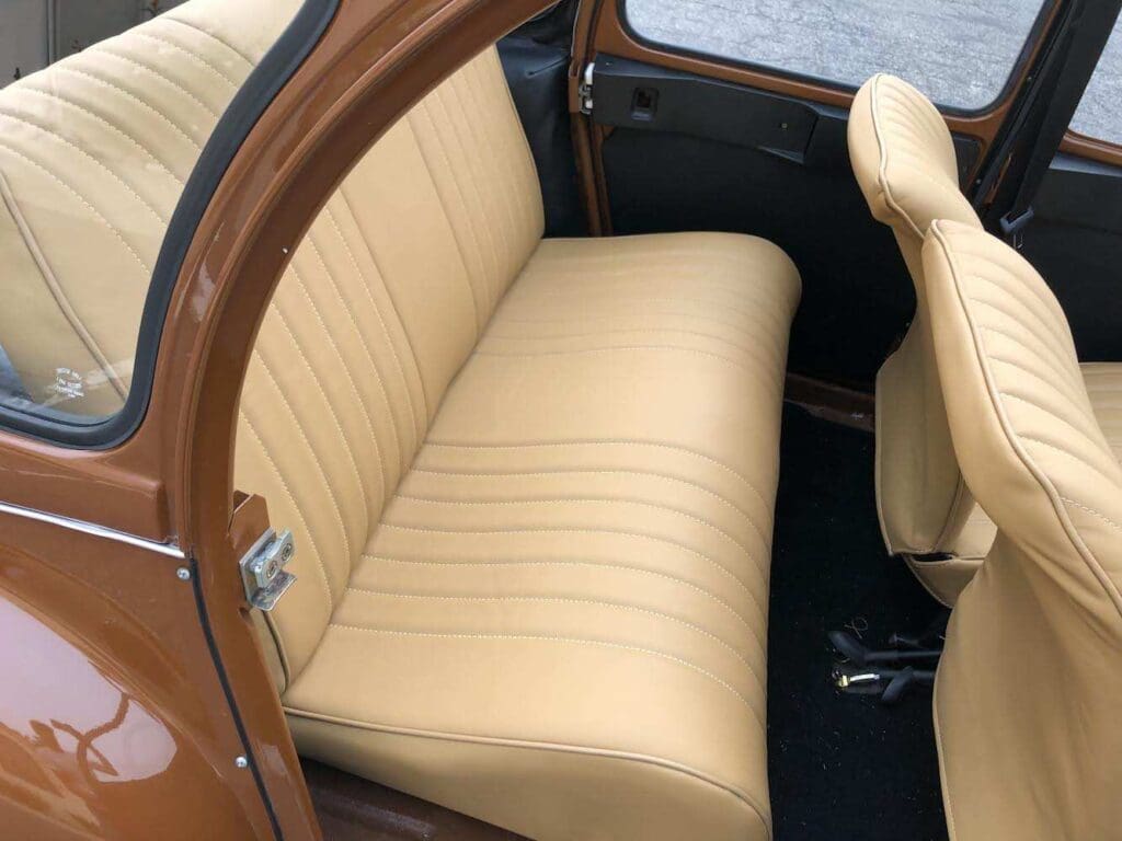 Classic car with tan leather rear seat upholstery.
