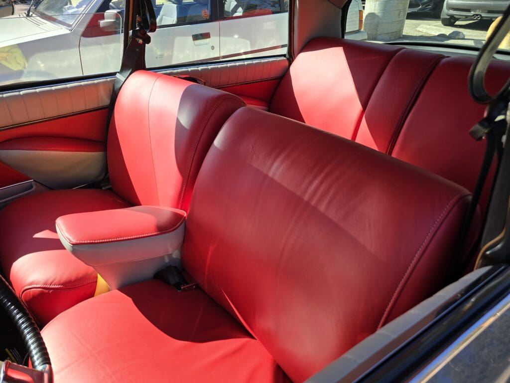 Red leather seats inside a vintage car.