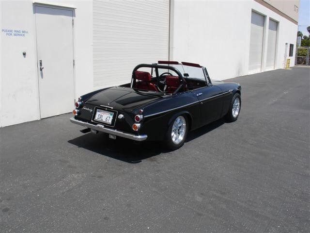 Classic black convertible sports car parked outdoors.
