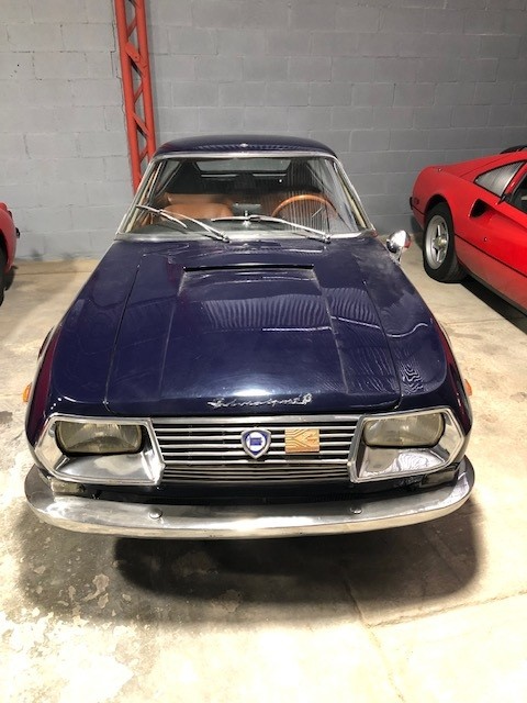Classic blue Maserati car in a showroom.