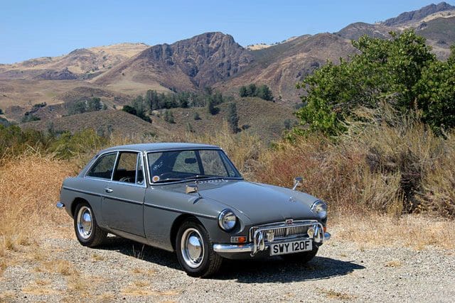 Classic vintage car parked on a mountain road.