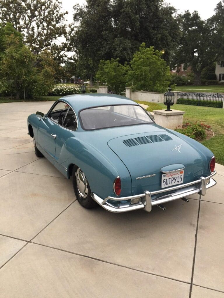 Classic blue Volkswagen Karmann Ghia parked on driveway.