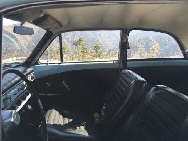 Interior of a vintage car showing front seats and dashboard.