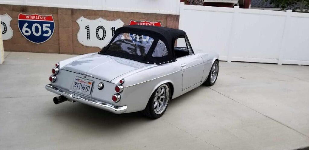 Classic silver convertible car parked indoors with vintage style.
