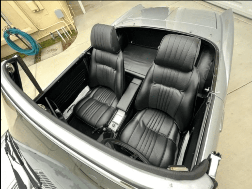 Interior of a classic car with black leather seats and a sleek dashboard.