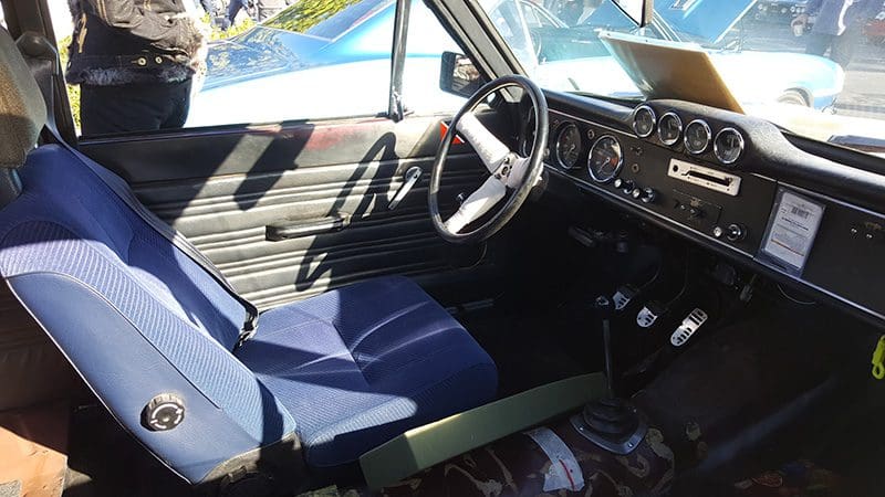 Interior of a vintage car showing the driver's seat and dashboard.