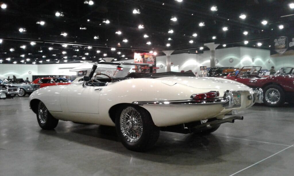 Classic white convertible sports car displayed indoors.