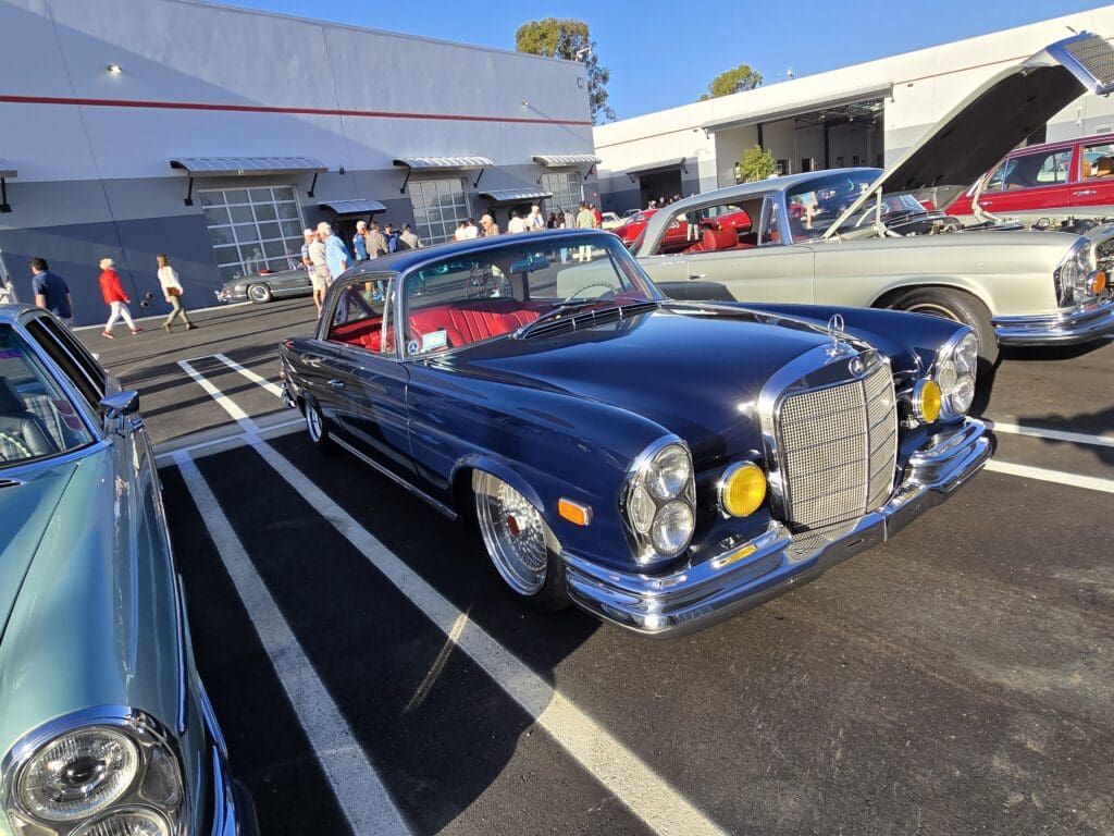 Classic blue Mercedes convertible parked outdoors on a sunny day.