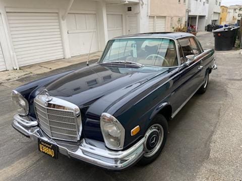 Classic black Mercedes-Benz parked near garage doors.