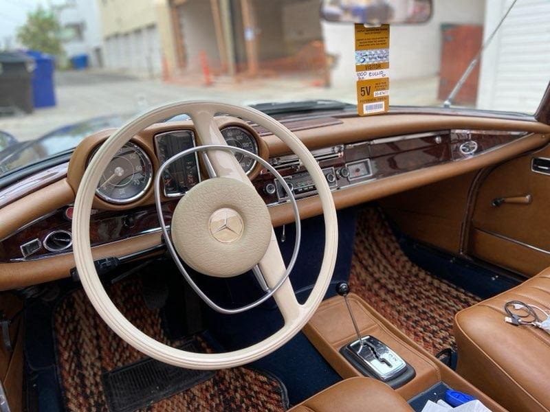 Vintage car interior with a classic steering wheel and dashboard.