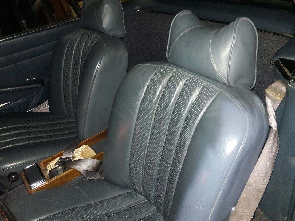 Close-up of black leather car seats with headrests.