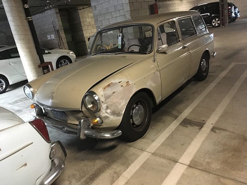 Classic beige vintage car parked indoors.
