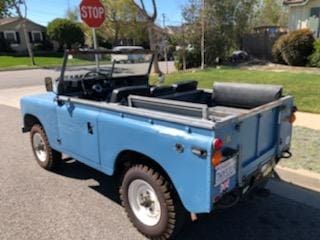 Light blue vintage convertible parked on a sunny street.