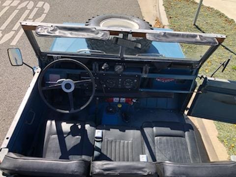 Interior view of a vintage off-road vehicle with a simple dashboard and steering wheel.