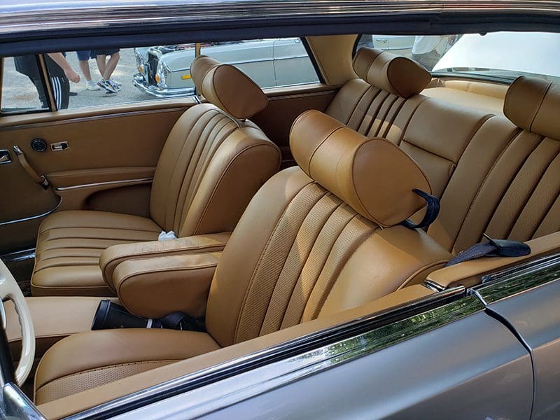 Luxurious tan leather car interior with bucket seats.