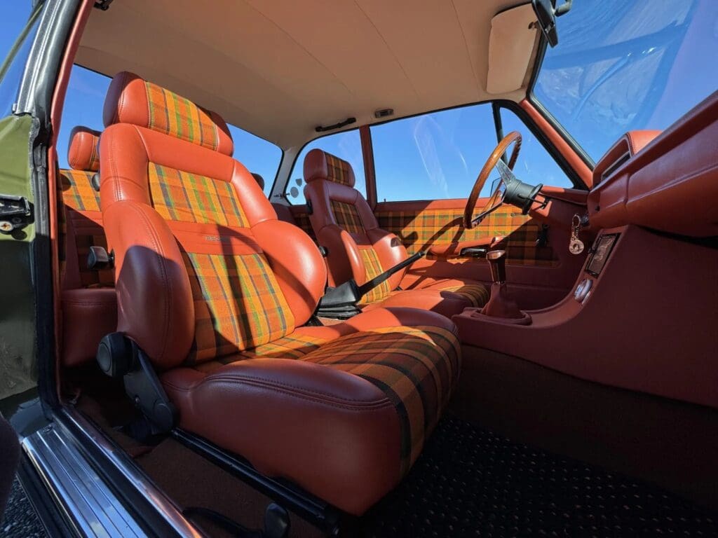 Vintage car interior with orange and brown striped seats.