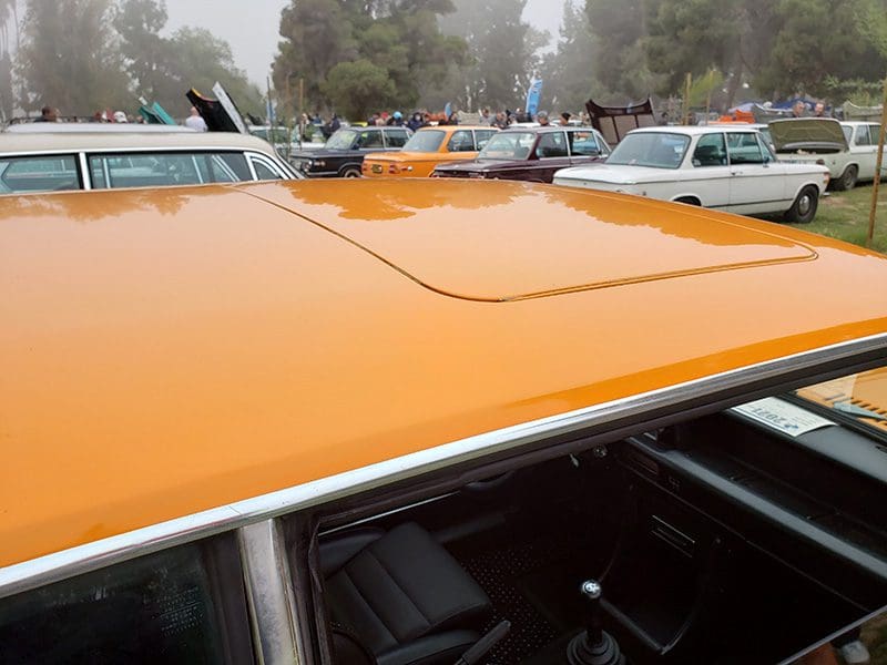 Close-up of a car's orange roof with a sunroof.