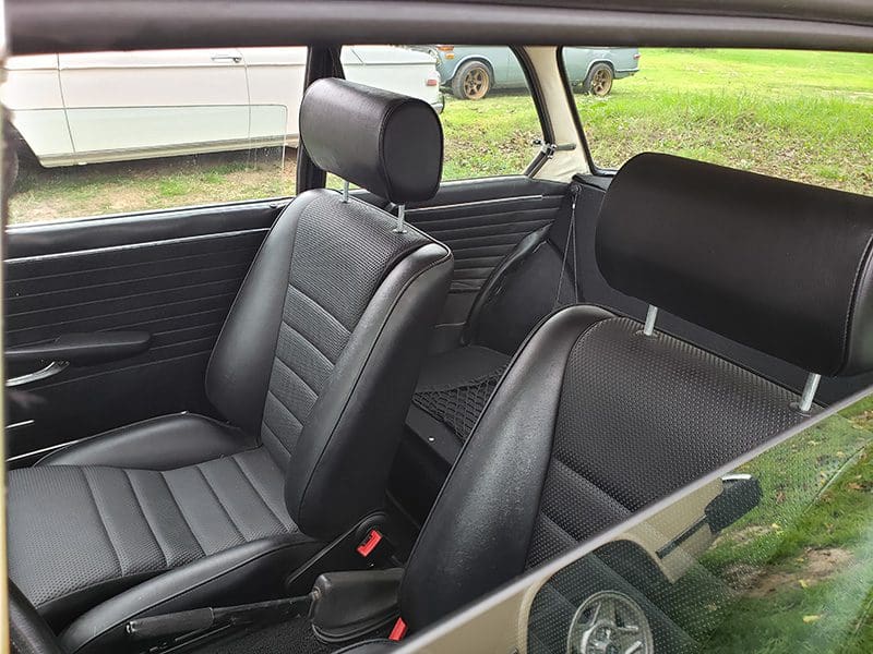 Interior view of a car with black leather seats and headrests.