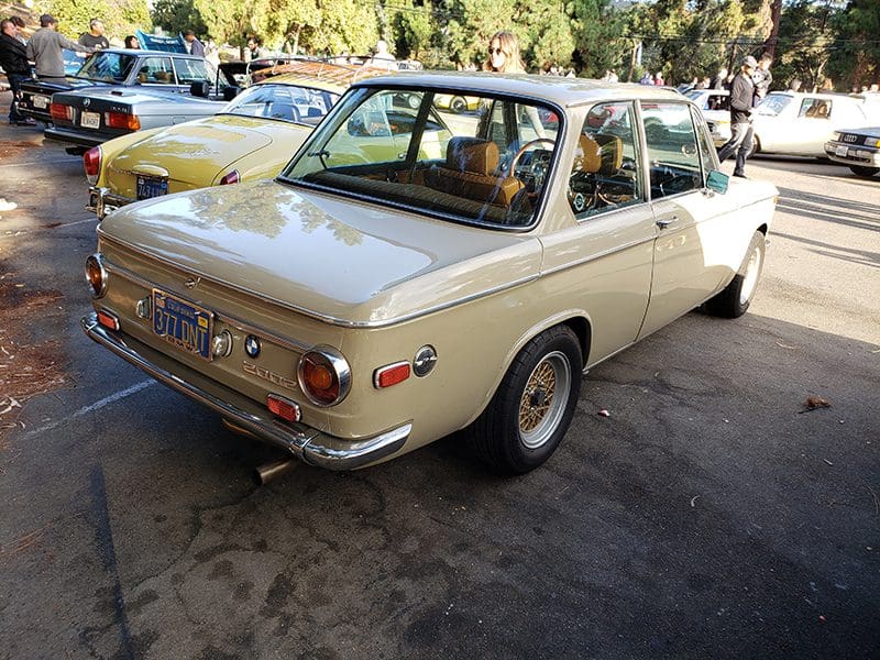 Classic beige vintage car parked outdoors.