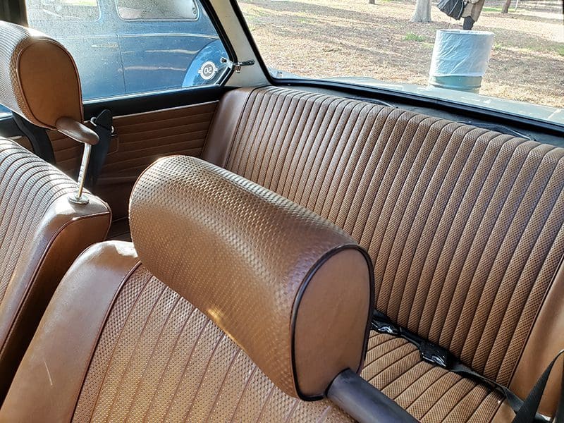 Close-up of vintage car's brown leather interior and backseat.