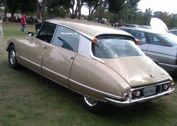 A vintage beige Citro&euml;n DS car parked on grass.