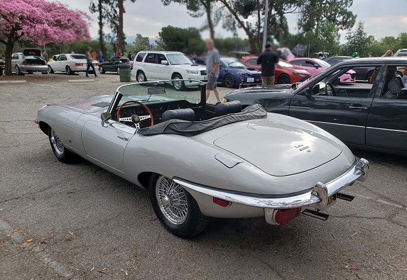 Classic silver convertible sports car parked by the curb.