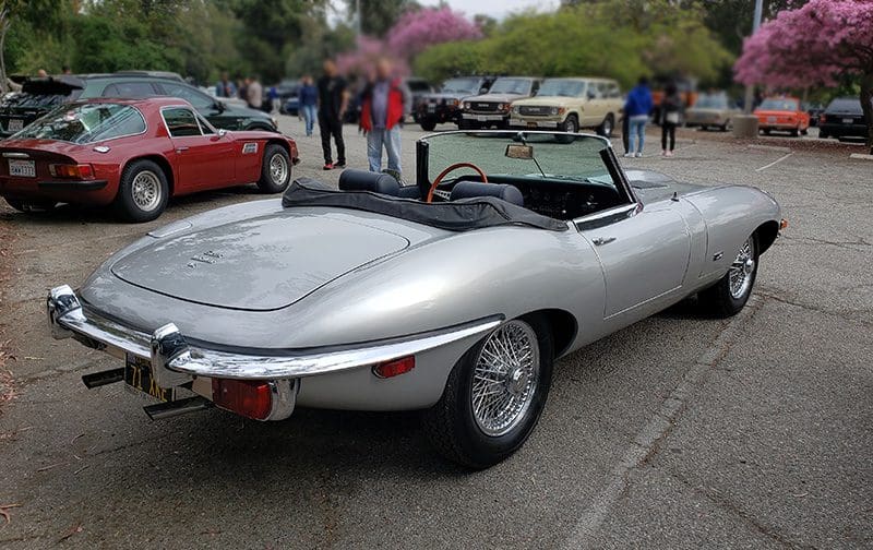 Classic silver convertible sports car parked at an outdoor event.