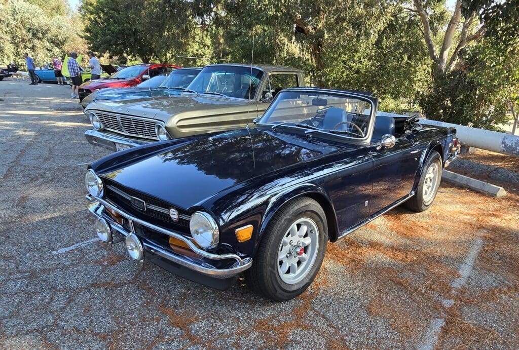 Classic black convertible sports car parked outdoors.