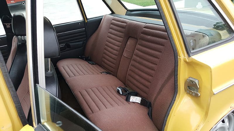 Vintage car interior with brown leather seats and classic design.