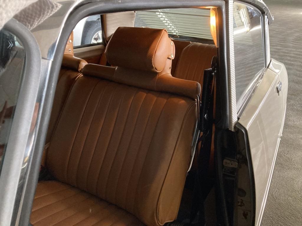 Interior of a vintage car with brown leather seats.