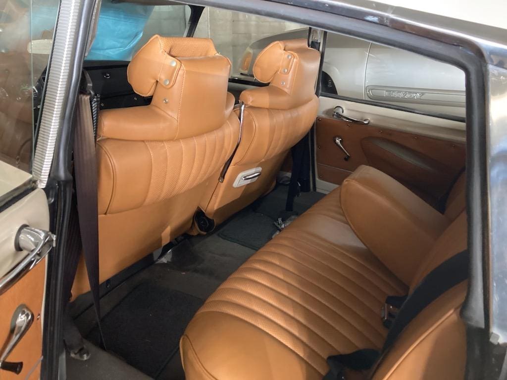 Vintage car interior with brown leather seats and elegant design.