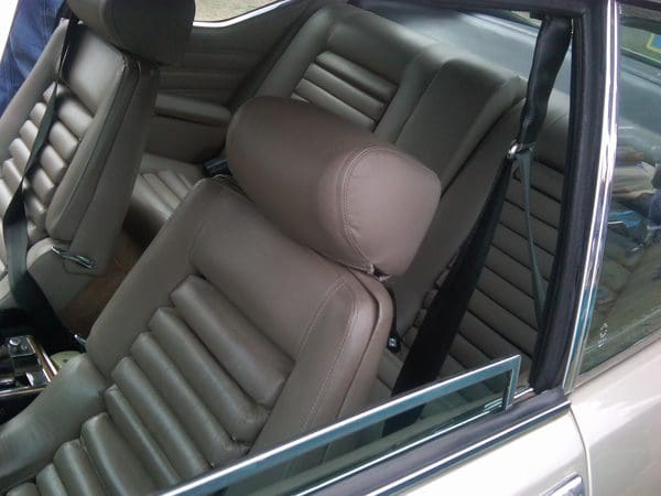 Interior of a car showing the driver's seat and headrest in brown leather.