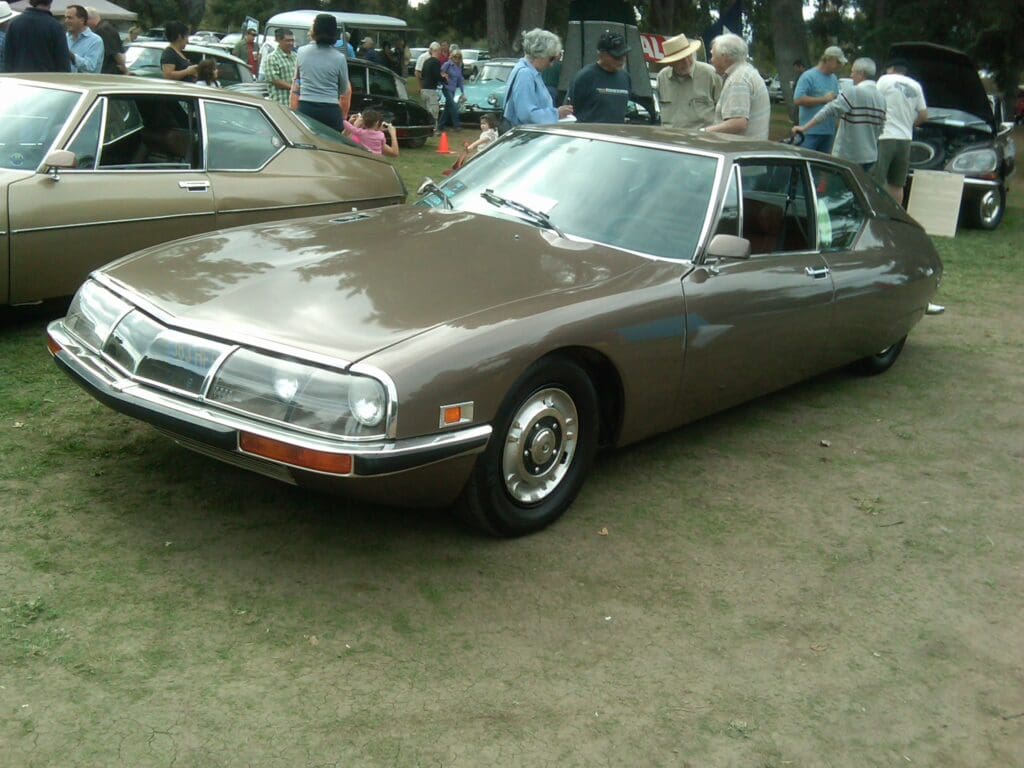 Classic brown Citroën SM parked outdoors at a car show.