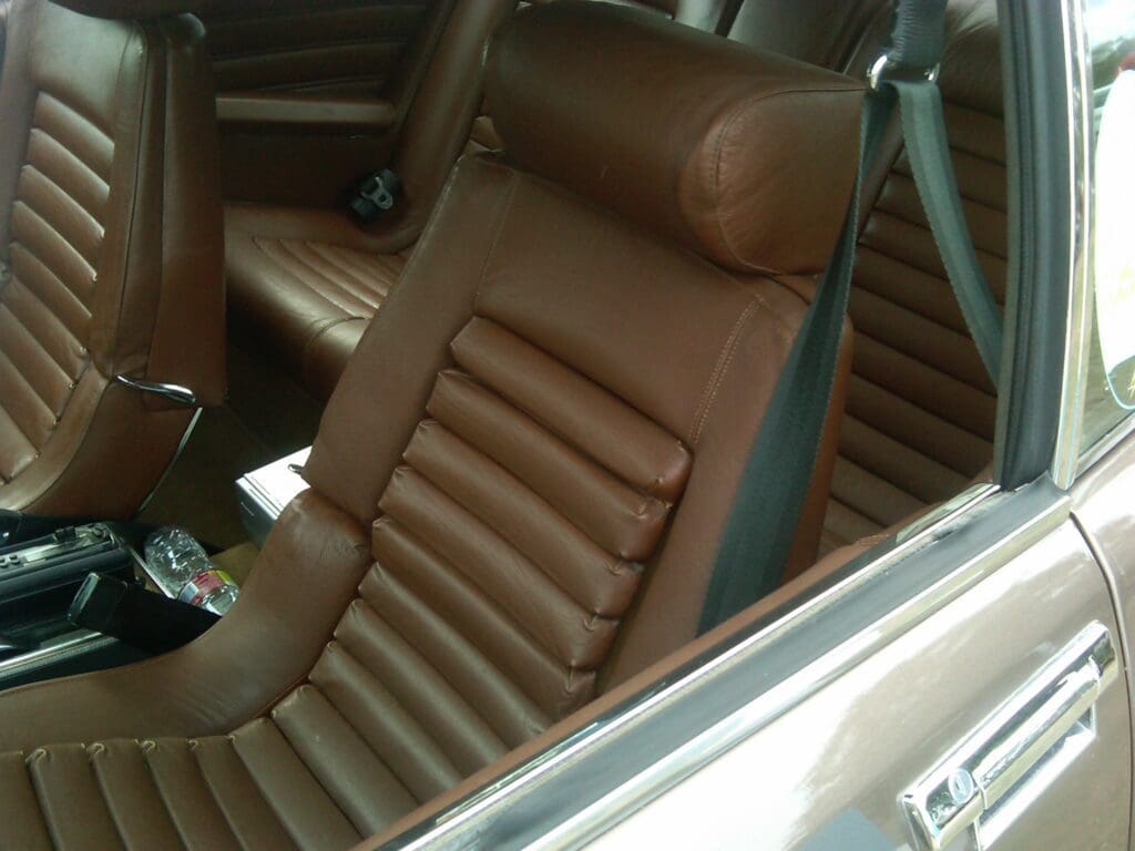 Close-up of a brown leather car seat with ribbed design.
