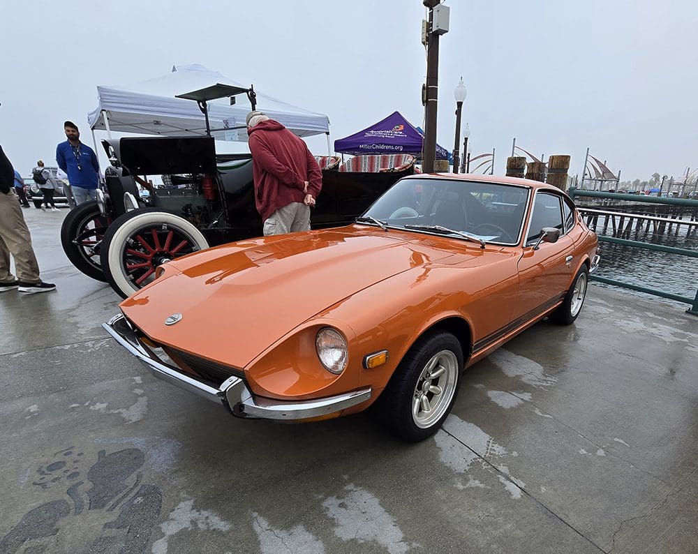 Orange vintage sports car on display at a car show.