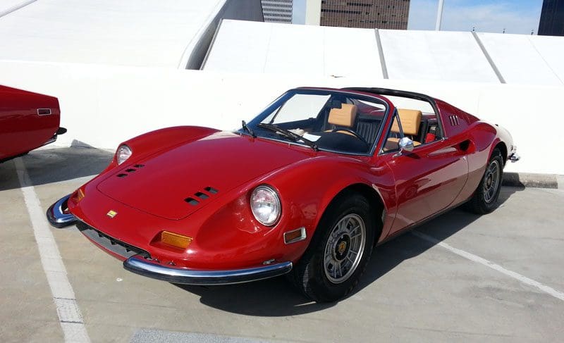 Classic red convertible sports car parked outdoors.
